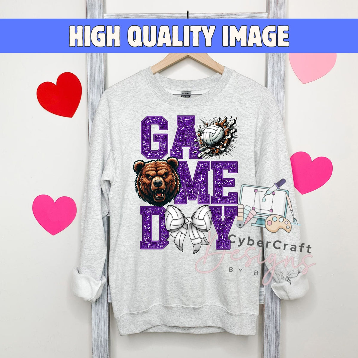 A light gray crewneck sweatshirt hanging on a wooden hanger, featuring a 'GAME DOME DAY' graphic in purple glitter-style lettering with a bear, volleyball, and bow design. The image has a blue banner at the top reading 'HIGH QUALITY IMAGE' and pink heart graphics on a white background.