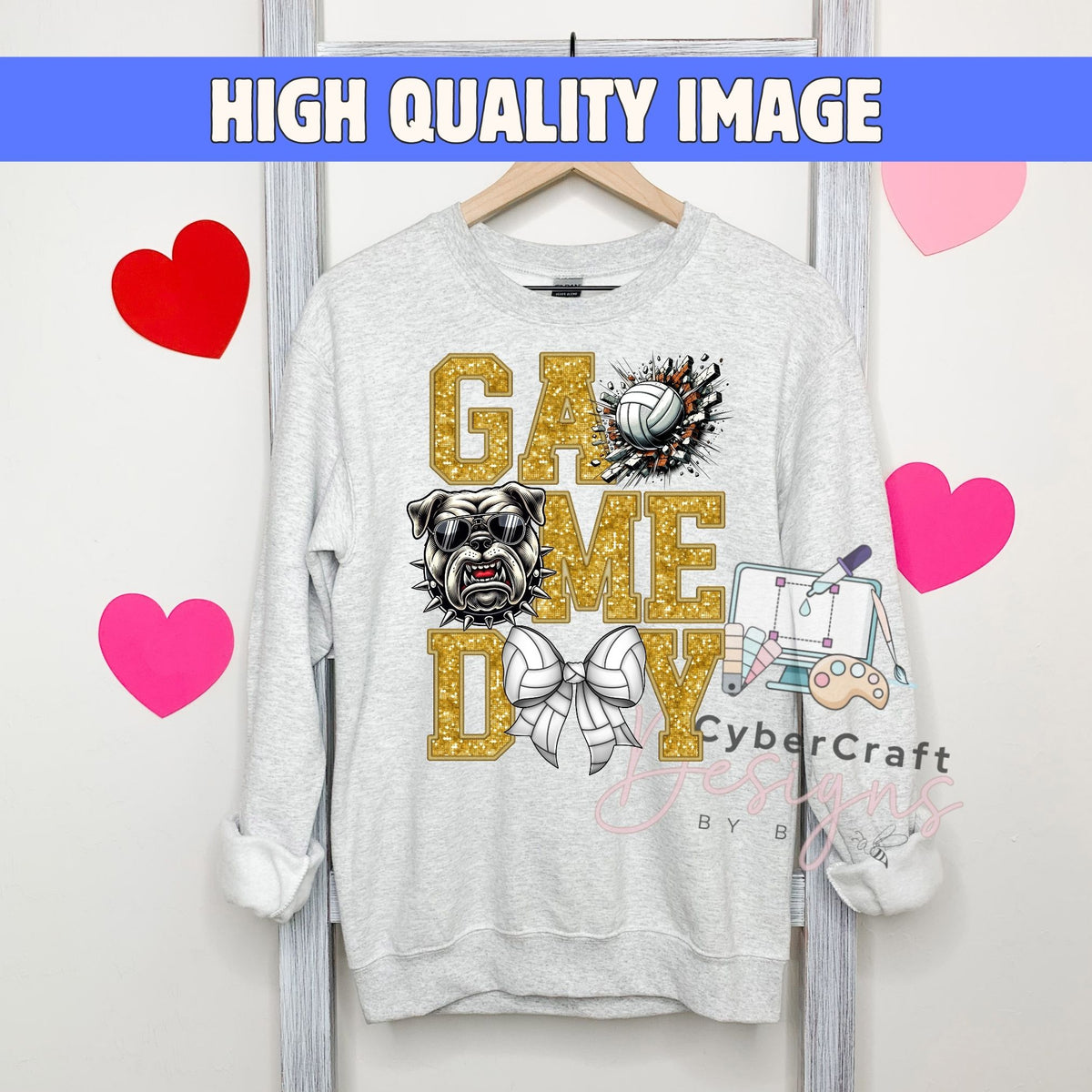 A light gray crewneck sweatshirt hanging on a wooden hanger, featuring a 'Game Day' graphic with a bulldog, volleyball, and gaming elements. The image has a blue banner at the top reading 'HIGH QUALITY IMAGE' and pink heart graphics on the sides.