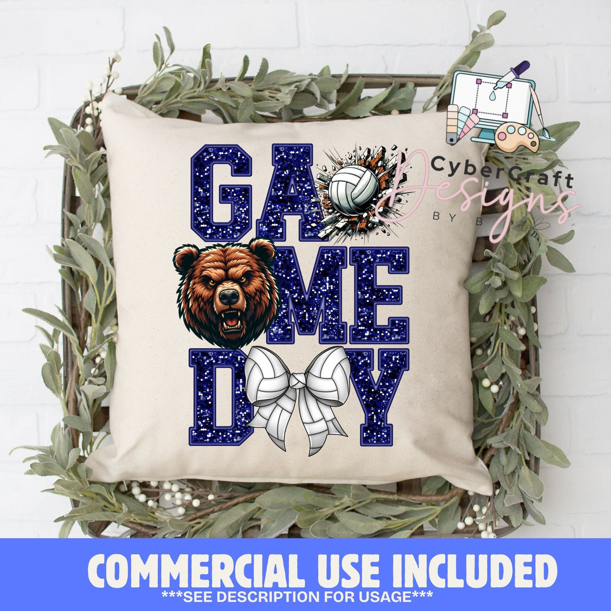 A square cream throw pillow with a 'GAME DAY' volleyball graphic, styled in a decorative wooden crate with green foliage. The graphic features navy blue glitter-textured letters, a brown bear illustration, and white volleyballs.
