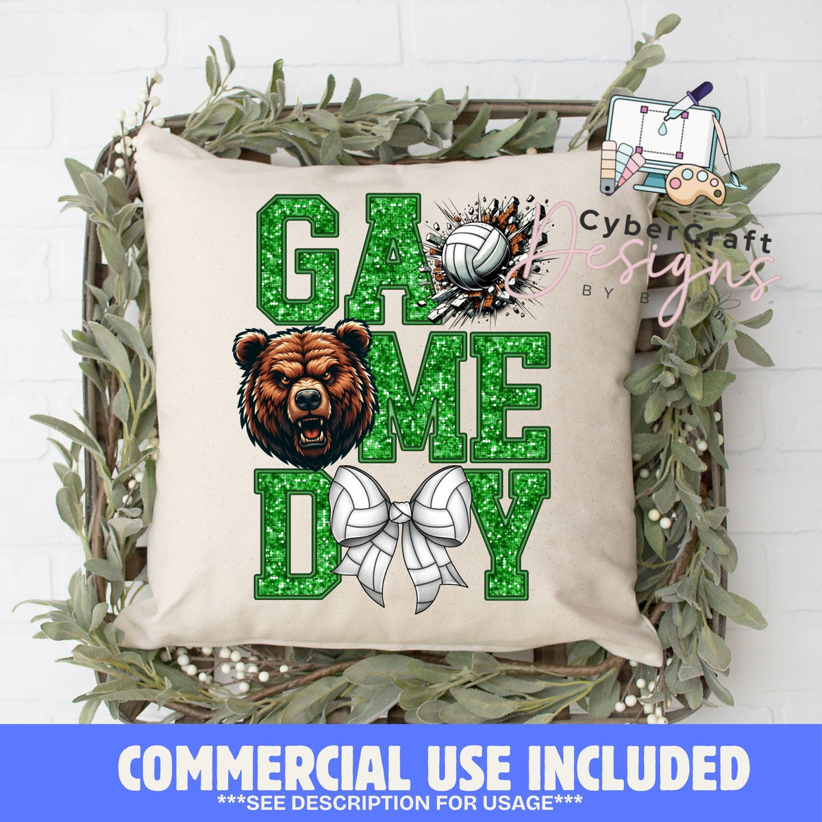 A square beige throw pillow with a green glitter-textured 'GAME DAY' design, featuring a brown bear face, a volleyball burst, and a white bow. The pillow is displayed in a rustic wooden crate decorated with green eucalyptus leaves, set against a white brick wall.