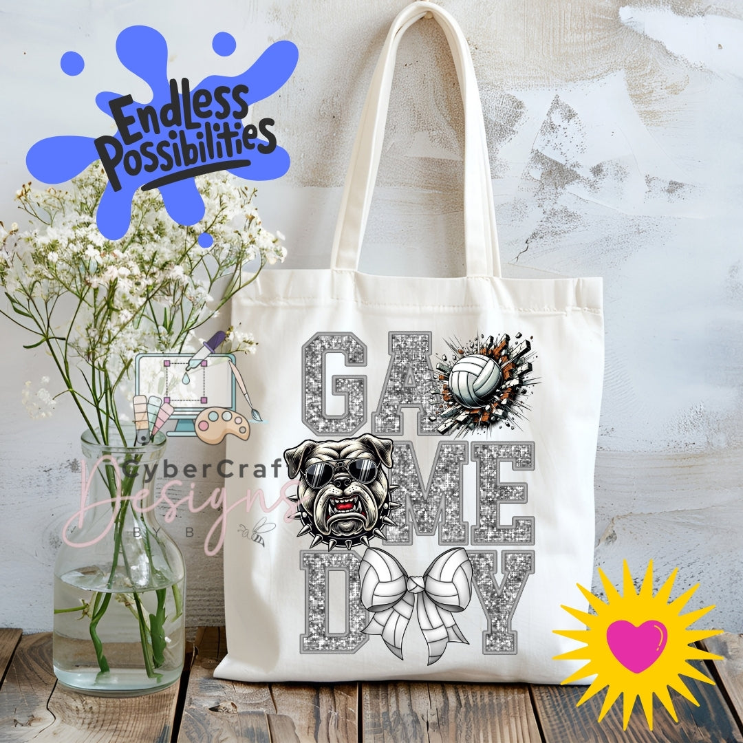 A cream canvas tote bag with a 'Game Day' bulldog and volleyball graphic, displayed on a rustic wooden table with a vase of baby's breath and decorative overlays.