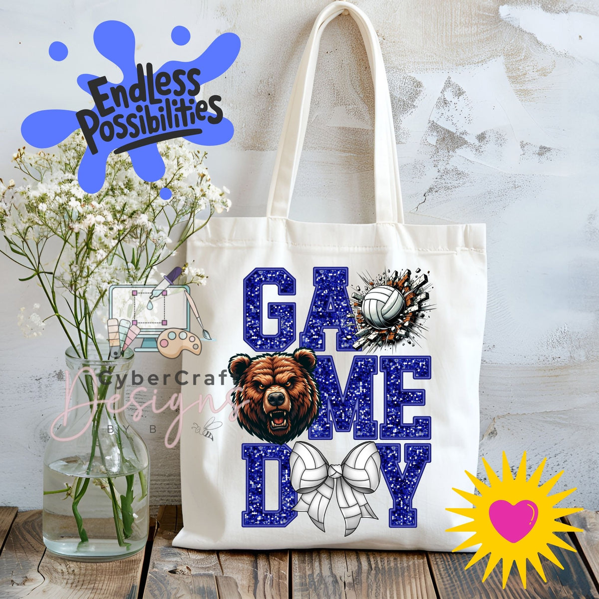 A white canvas tote bag with 'GAME DAY' printed in blue glitter-style letters, featuring a bear head graphic, a volleyball, and a bow design. The bag is displayed on a wooden surface next to a vase of white flowers, with decorative digital overlays including 'Endless Possibilities' and 'CyberCraft Designs'.