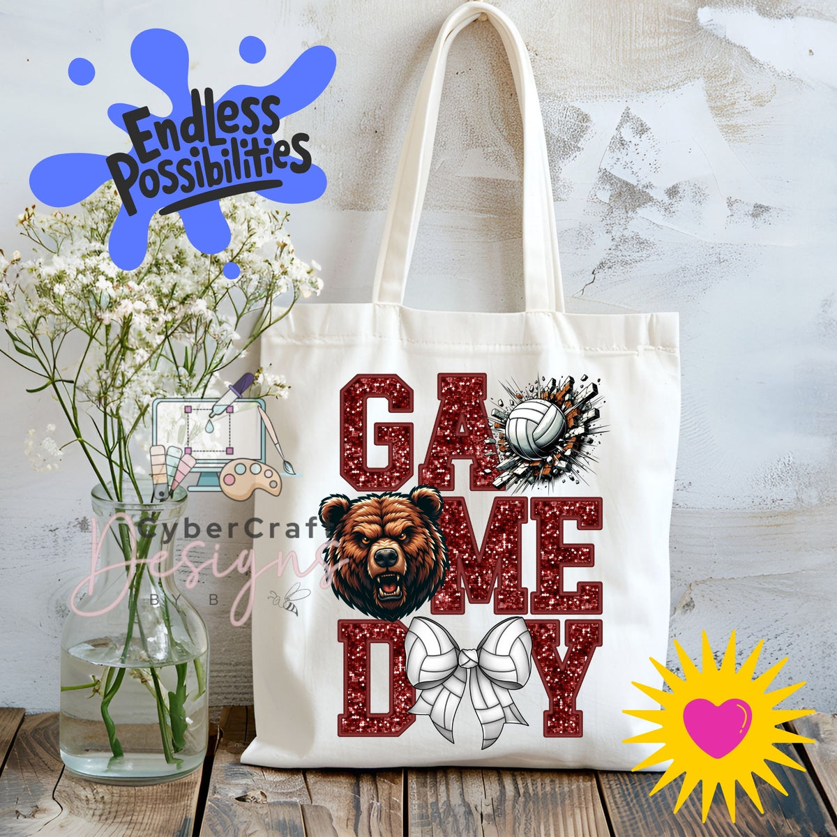 A white canvas tote bag with 'GAME DAY' printed in red glitter-style letters, featuring a bear head graphic, a volleyball, and a bow. The bag is displayed on a wooden surface next to a glass vase with white flowers, with decorative digital overlays including 'Endless Possibilities' and a yellow heart sunburst.