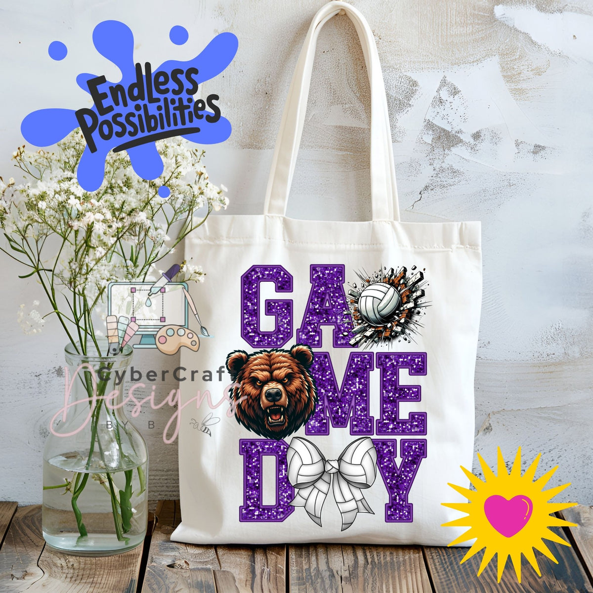 A white canvas tote bag with 'GAME DAY' printed in purple glitter-style letters, featuring a bear head graphic, a volleyball, and a bow design. The bag is displayed on a rustic wooden table next to a glass vase of white flowers, with decorative digital overlays including 'Endless Possibilities' and a yellow starburst heart.