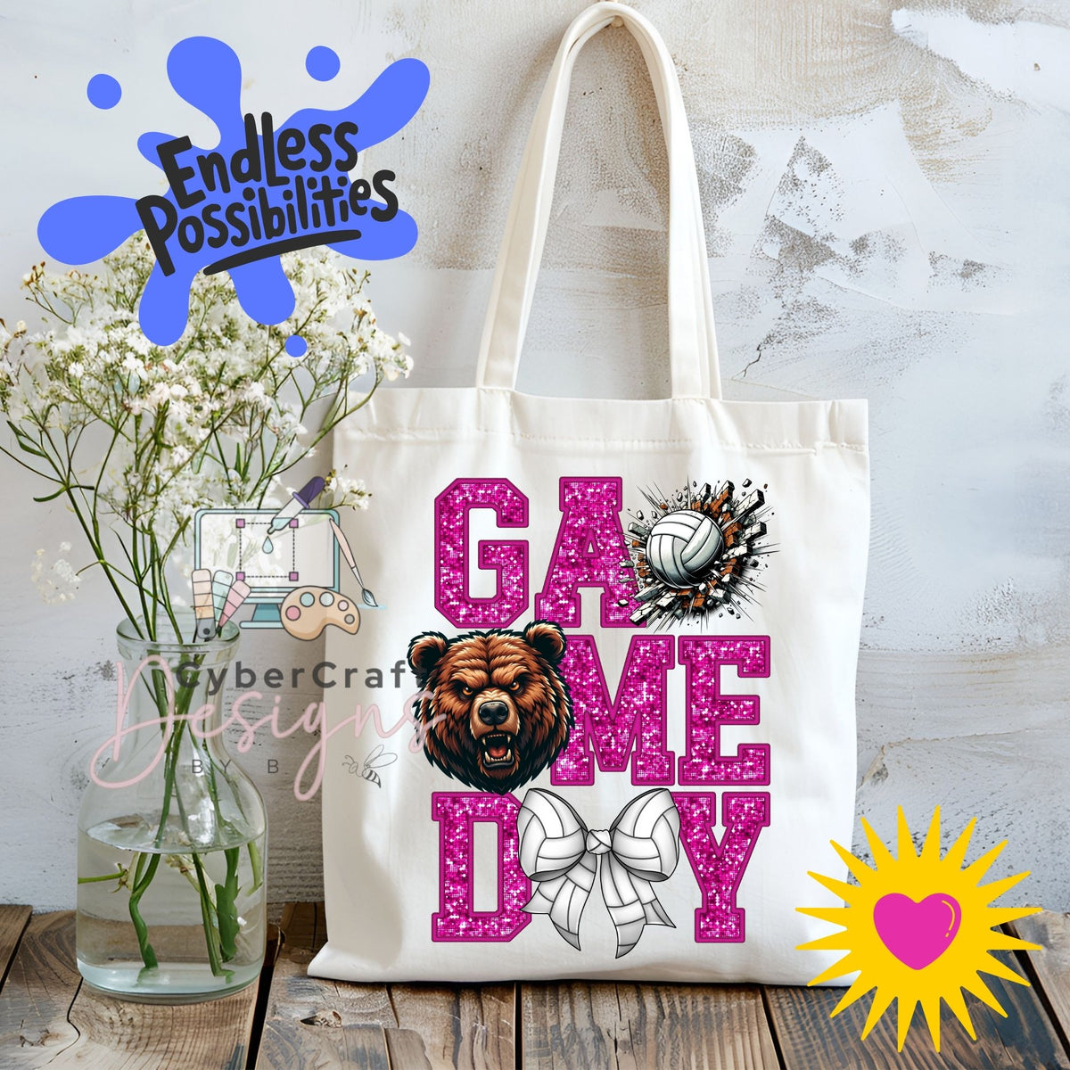 A white canvas tote bag with 'GAME DAY' printed in glittery pink letters, featuring a brown bear graphic, a volleyball, and a bow design. The bag is displayed on a rustic wooden table next to a glass vase of white flowers, with decorative digital overlays including 'Endless Possibilities' and 'CyberCraft Designs'.